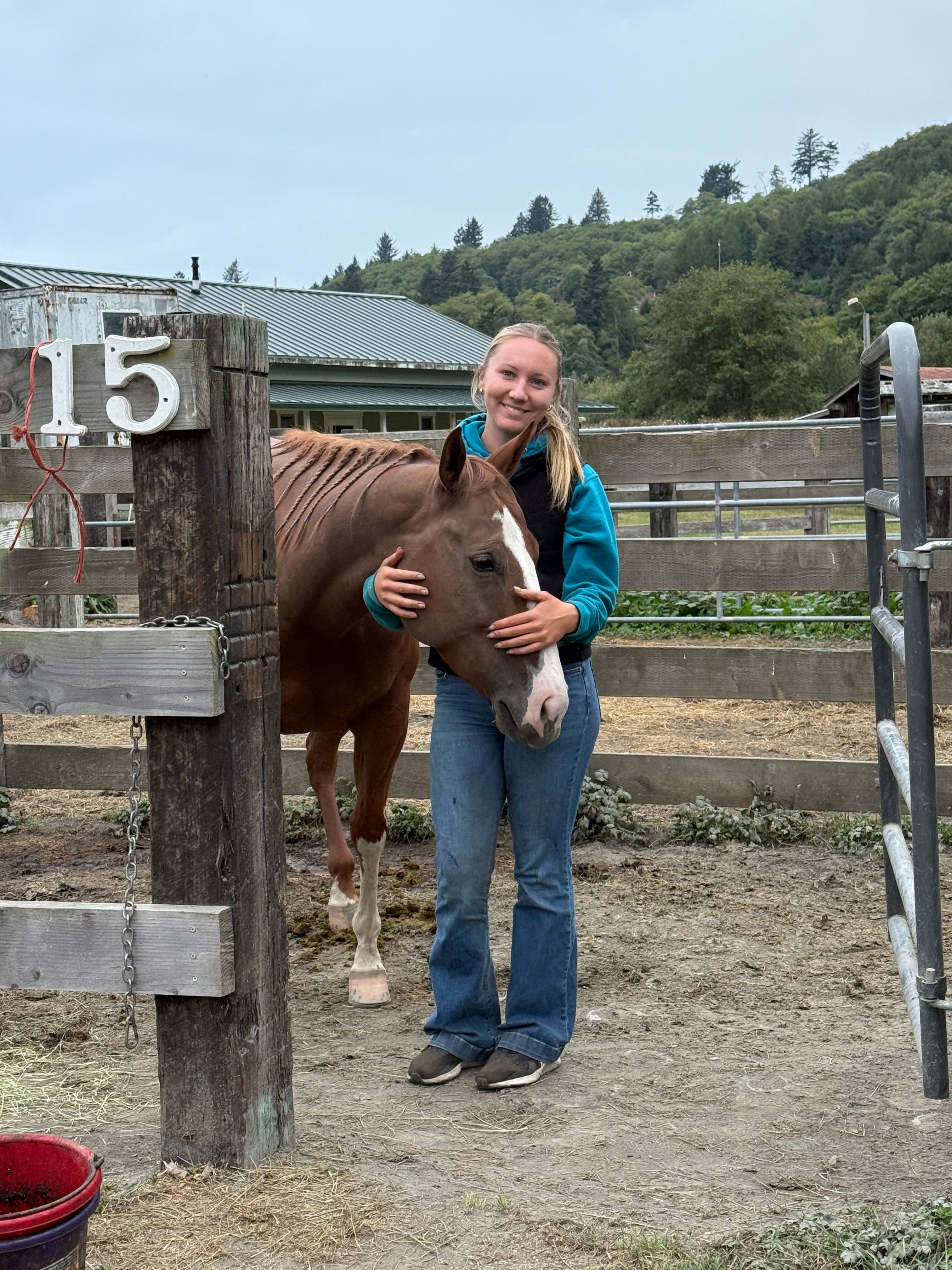 Courtney Sabral standing with one of her Quarter Horse mares