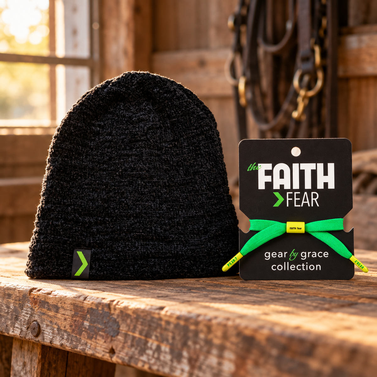 Black Faith > Fear knit beanie and Hope Green LaceBand bracelet together on a wooden tack-room bench